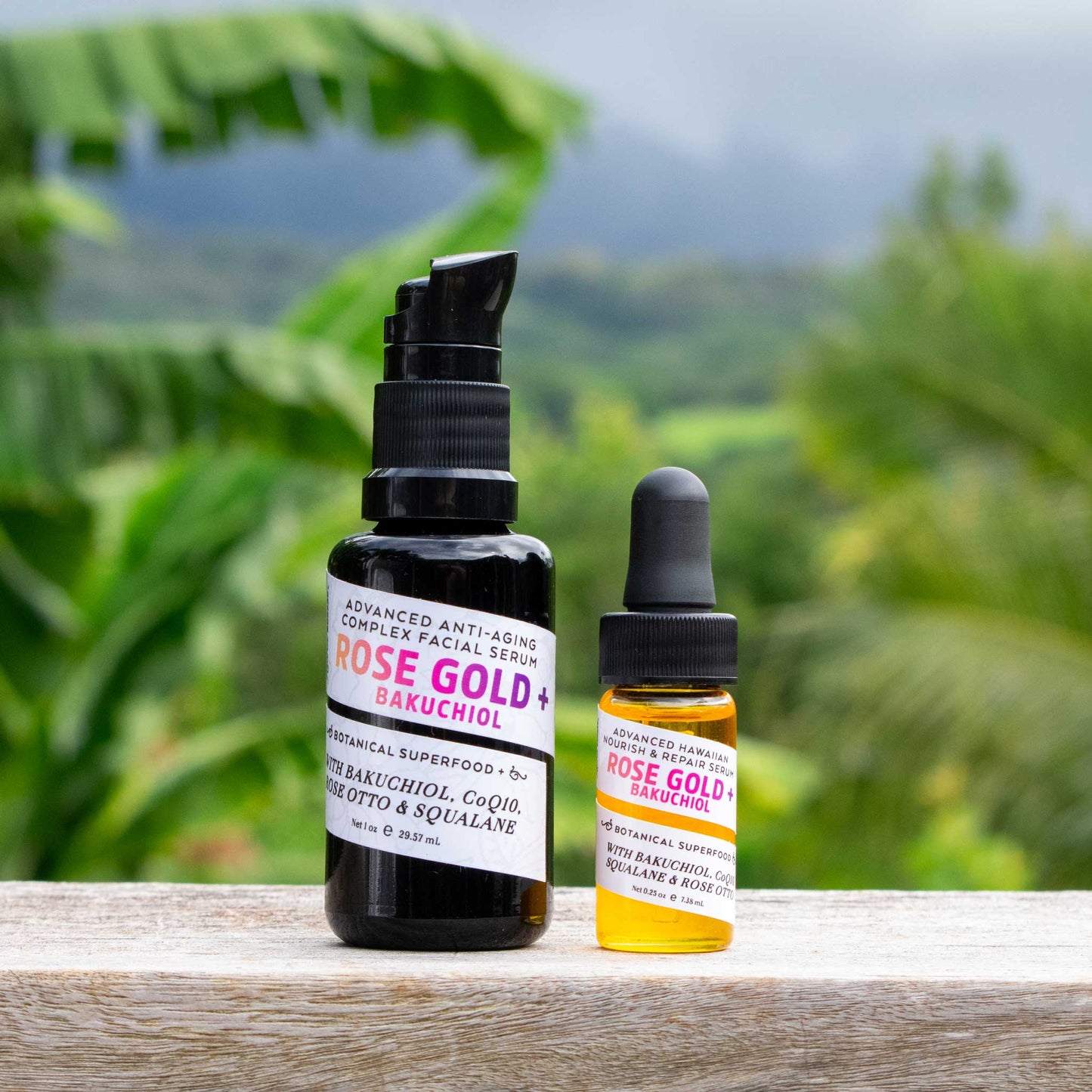 Rose Gold + Bakuchiol 1oz and 0.25 oz serum bottles with Kaua'i forrest in the background